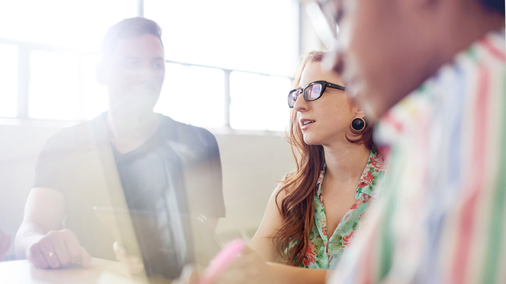 Three diverse individuals engage in a discussion, emphasizing intellectual integrity during a career-related meeting.