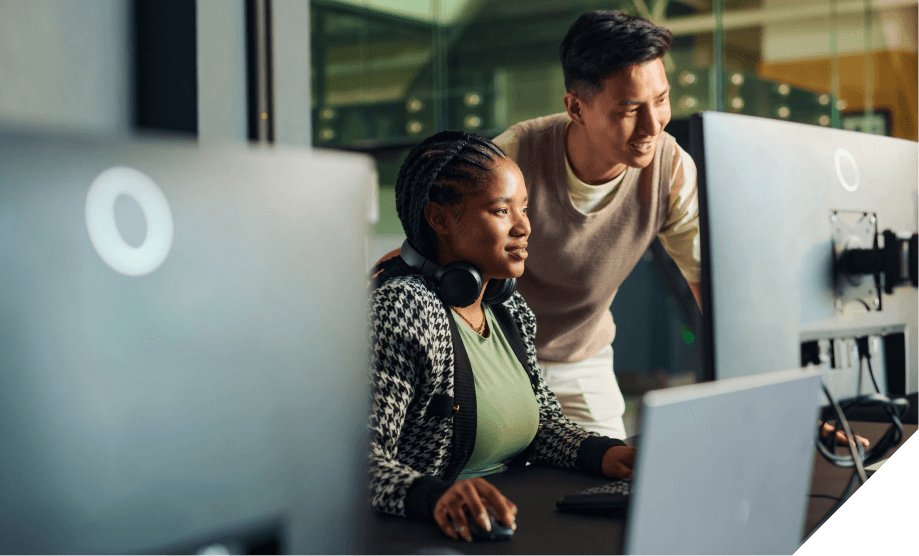 Two individuals collaborate at a computer station in a modern office, emphasizing cloud computing and teamwork.